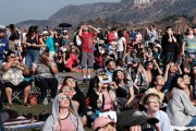 A crowd gathers in front of the Hollywood sign at the Griffith Observatory to watch the solar eclipse in Los Angeles on Monday, Aug. 21, 2017. (AP Photo/Richard Vogel)