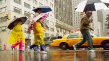 This Oct. 2005 file photo shows people walking across Fifth Avenue during rainfall.