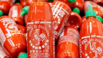 File - Sriracha chili sauce bottles are produced at the Huy Fong Foods factory in Irwindale, Calif., on Tuesday, Oct 29, 2013. The maker of Sriracha hot sauce is under fire for allegedly fouling the air around its Southern California production site. The city of Irwindale filed a lawsuit in Los Angeles Superior Court Monday asking a judge to stop production at the Huy Fong Foods factory, claiming the chili odor emanating from the facility is a public nuisance. (AP Photo/Nick Ut)