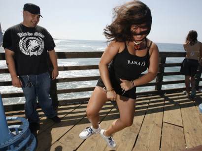 On the Oceanside Municipal Pier on Saturday near her husband, Mathew, Mateo demonstrates the dance she did when she found her California Lottery ticket was a winner.