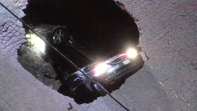 Woman rescued after sinkhole swallows auto Woman rescued after sinkhole swallows auto