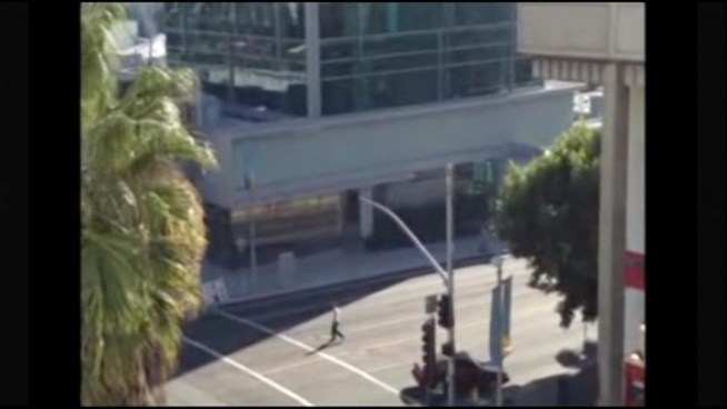 Warning: disturbing content -- A gunman walking down the middle of the street fires into a moving vehicle and the chilling incident was captured on video.