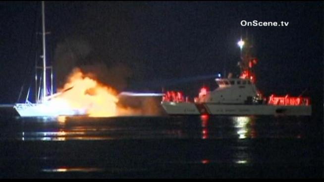 Rescue crews bring a sailor ashore as fire crews fight a fire aboard his boat off Malibu. Raw video