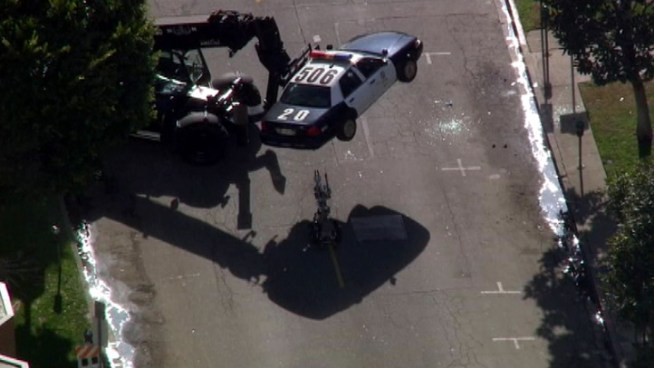 A specially equipped LAPD bomb squad vehicle was used Tuesday to lift a squad car off the street. Raw Video