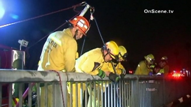 Rescue crews hoist a man to safety after he jumped into a flood control channel during a run from sheriff's deputies, according to fire officials.