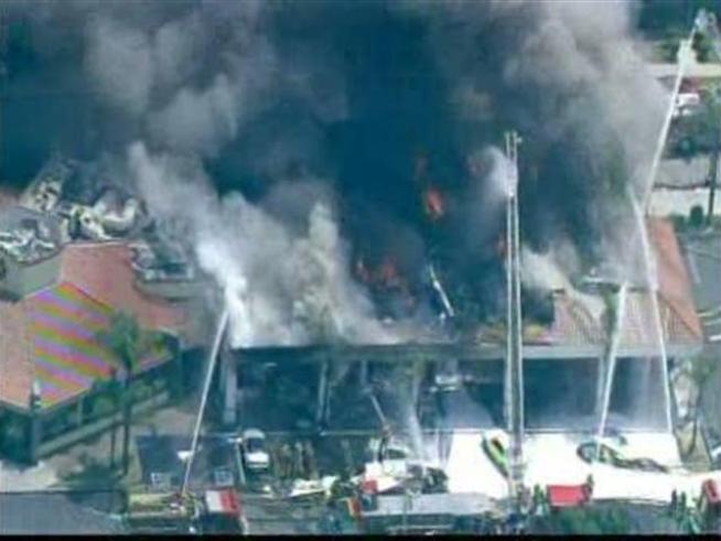 Firefighters work to contain a fire at a strip mall.