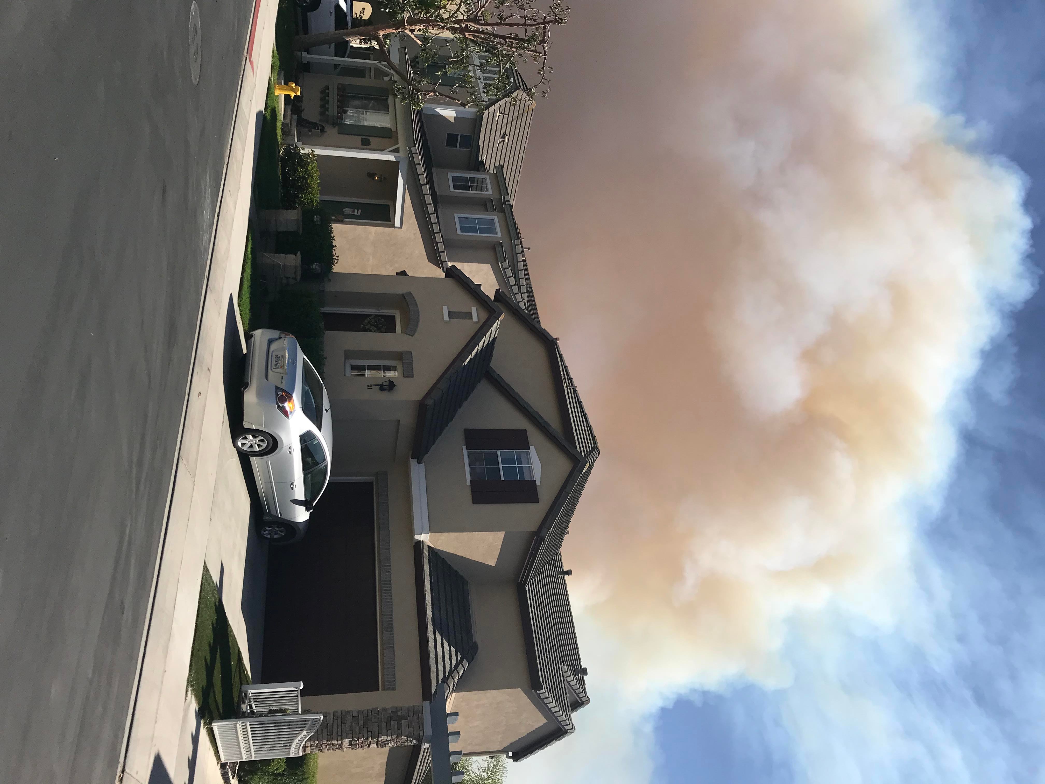 Smoke from a fire in Aliso Viejo behind village cottages
