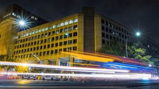 In this Nov. 1, 2017, file photo, traffic along Pennsylvania Avenue streaks past the Federal Bureau of Investigation headquarters building in Washington, D.C.