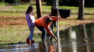 Barbara Beavers and her daughter measure rising floodwaters in Mississippi