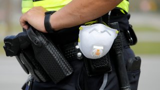 a North Charleston police officer carries a protective mask around his gun belt