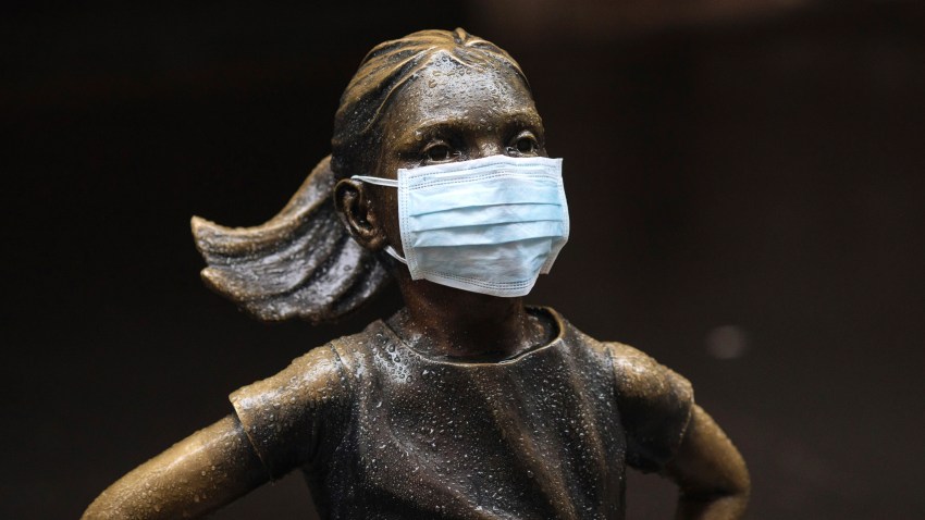 In this file photo, a surgical mask is placed on The "Fearless Girl" statue outside the New York Stock Exchange on Thursday, March 19, 2020, in New York.