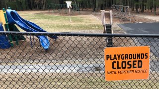 This Friday, March 20, 2020 file photo shows a closed sign near an entrance to a playground