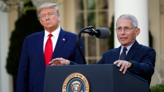 Dr. Anthony Fauci and Donald Trump at the podium during a coronavirus task force briefing