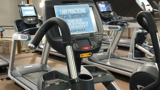 A sign on posted on gym equipment, advises patrons to practice social distancing amid the COVID-19 virus outbreak at Bodyplex Fitness Adventure on Friday, April 24, 2020, in Grayson, Ga. Gov. Brian Kemp announced this week the resumption of elective medical procedures, as well as the reopening of certain close-contact businesses like gyms, barbershops and tattoo parlors.