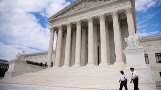 In this May 14, 2020, file photo security officers walk in front of the Supreme Court in Washington.