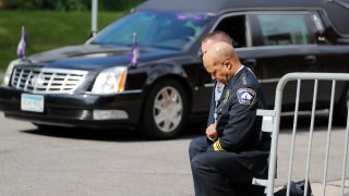 Police officers including Minneapolis Police Chief Medaria Arradondo, foreground, take a knee as the body of George Floyd arrives before his memorial services on Thursday, June 4, 2020 in Minneapolis.