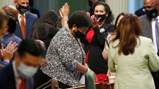 Assemblywoman Shirley Weber, D-San Diego, center, receives applause from fellow lawmakers after the Assembly approved her measure to place a constitutional amendment on the ballot to let voters decide if the state should overturn its ban on affirmative action programs, at the Capitol in Sacramento, Calif., Wednesday, June 10, 2020.