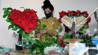 FILE - In this May 10, 2020, file photo, a merchant prepares a floral arrangement on Mother's Day at the Los Angeles Flower Market in Los Angeles. Americans are more unhappy today than they’ve been in nearly 50 years. That's according to the COVID Response Tracking Study, conducted in late May by NORC at the University of Chicago.