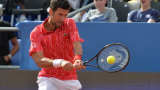 Serbia's Novak Djokovic returns the ball during an exhibition tournament in Zadar, Croatia, Sunday, June 21, 2020. Tennis player Grigor Dimitrov says he has tested positive for COVID-19 and his announcement led to the cancellation of an exhibition event in Croatia where Novak Djokovic was scheduled to play on Sunday.