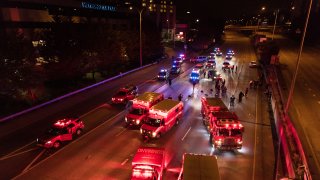Emergency personnel work at the site where a driver sped through a protest-related closure on the Interstate 5 freeway in Seattle