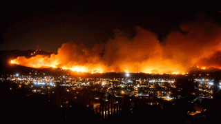 In this Oct. 31, 2019, file photo, smoke from a wildfire known as the Maria Fire billows above Santa Paula, Calif.