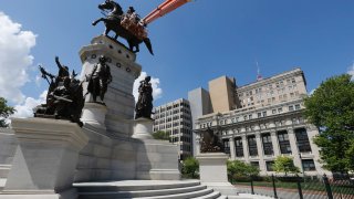 Workers make finishing touches on the restoration of the Capitol square statue of George Washington in Richmond, Va. Thousands of gun activists are expected to turn out here in a show of force against new gun control laws.