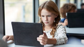A file image of a girl reading on tablet