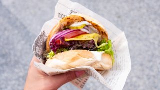 Person holding a cheeseburger