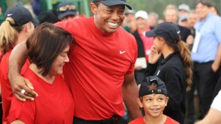 Tiger Woods of the United States celebrates with his mom and son Charlie Axel