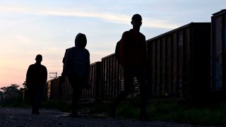 In this July 25, 2019, photo, migrants walk near a train known as “The Beast” in Palenque, Chiapas state, Mexico.