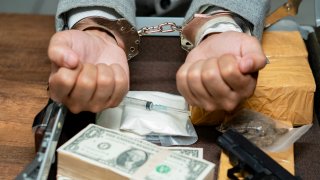 File Image: Drugs money and gun on wooden table,