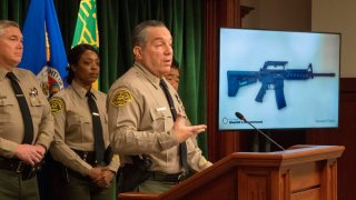 File Image: Los Angeles County Sheriff, Alex Villanueva, speaks beside an image of a seized semi-automatic weapon as he briefs the media after the arrest of a 13-year-old boy who allegedly threatened to carry out a shooting at Animo Mae Jemison Charter Middle School, in Los Angeles, California on November 22, 2019. – The weapon was found in the boy’s home along with 100 rounds of ammunition and a list of intended victims.