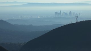 In this Nov. 5, 2019, file photo, the buildings of downtown Los Angeles are partially obscured in the afternoon as seen from near Pasadena, California. The air quality for metropolitan Los Angeles was predicted to be "unhealthy for sensitive groups" by the South Coast Air Quality Management District.