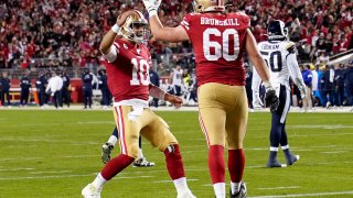 Quarterback Jimmy Garoppolo #10 and offensive tackle Daniel Brunskill #60 of the San Francisco 49ers celebrate after a touchdown in the second quarter of the game against the Los Angeles Rams at Levi’s Stadium on December 21, 2019 in Santa Clara, California.