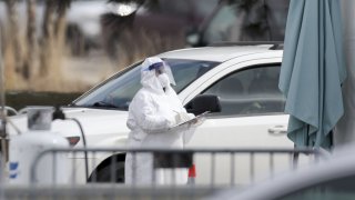 A medical worker holds a clipboard at a drive-thru Covid-19 testing location in the parking lot outside a Walmart store in Northlake, Illinois, U.S., on Monday, March 23, 2020. Illinois Governor J.B. Pritzker issued a shelter-in-place order to take effect Saturday at 5 p.m., following California and New York as more states restrict the movement of their residents to combat the new coronavirus.