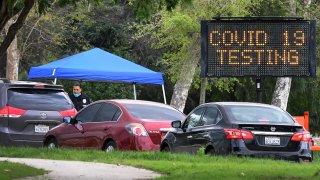A police officer mans the entrance to a coronavirus (COVID-19) testing center in Hansen Dam Park on March 25, 2020 in Pacoima, California. – (Photo by Frederic J. BROWN / AFP) (Photo by FREDERIC J. BROWN/AFP via Getty Images)