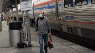 A passenger wearing a protective face mask arrives in Orlando, Florida on a nearly empty southbound Amtrak train on April 15, 2020.