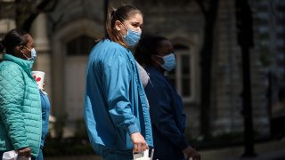 Health care workers wearing protective masks hold take-out food in Chicago