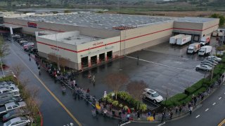 Hundreds of customers wait in line to enter a Costco store on March 14, 2020 in Novato, California. (Photo by Justin Sullivan/Getty Images)