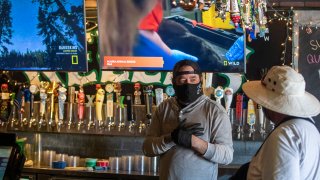 A bartender chats with a customer.