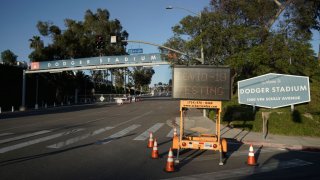 A “Covid-19 Testing” sign stands outside Dodger Stadium in Los Angeles, California, U.S., on Wednesday, May 27, 2020. Hertz Global Holdings Inc. will sell as many of its rental cars as possible while in bankruptcy to bring its huge fleet in line with reduced future demand in a post-pandemic economy, the company’s lead bankruptcy lawyer said during a court hearing Wednesday.
