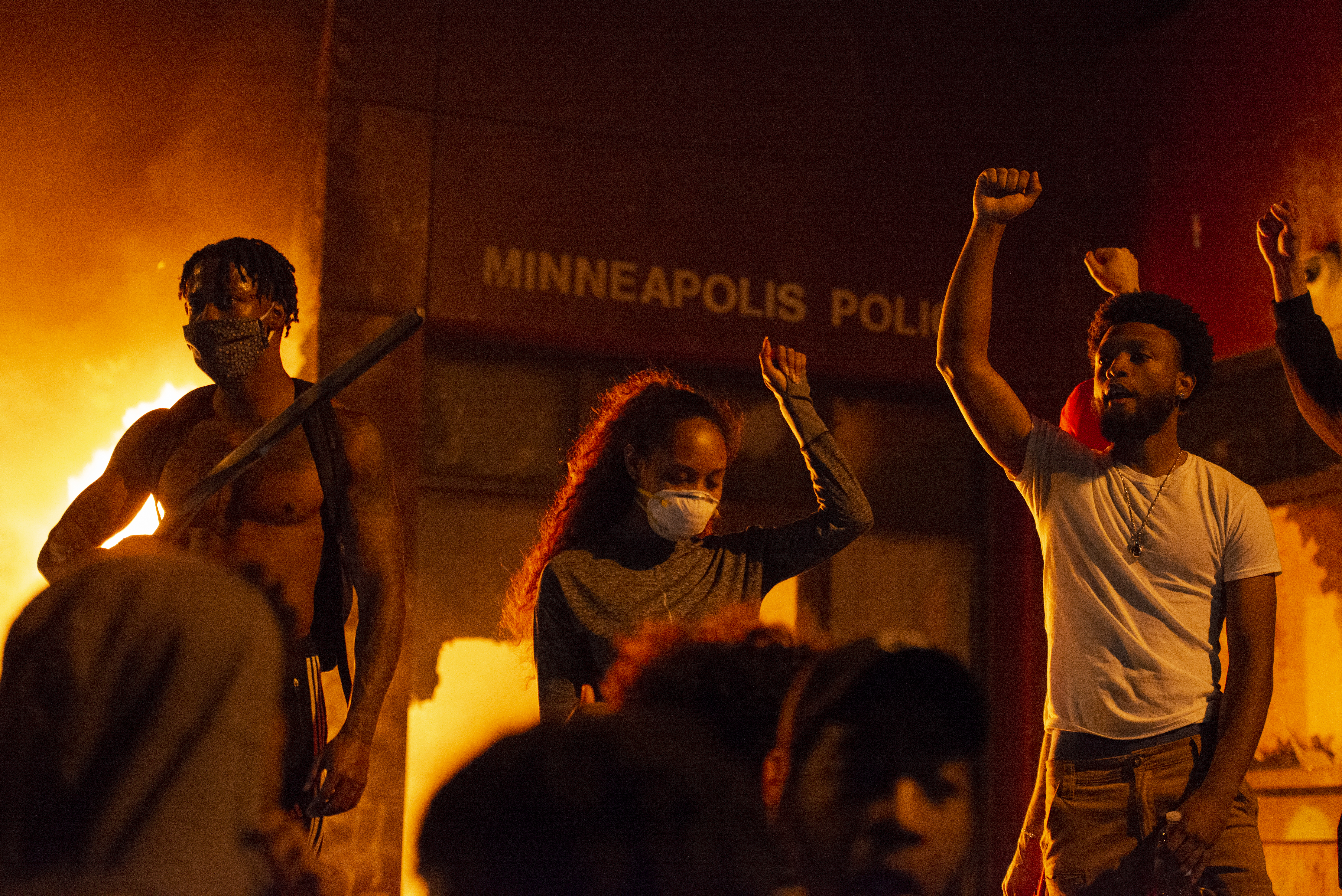 Protesters raise a fist in front of the burning Minneapolis 3rd police precinct on Thursday, May 28, 2020, during the third day of protests over the death of George Floyd in Minneapolis.