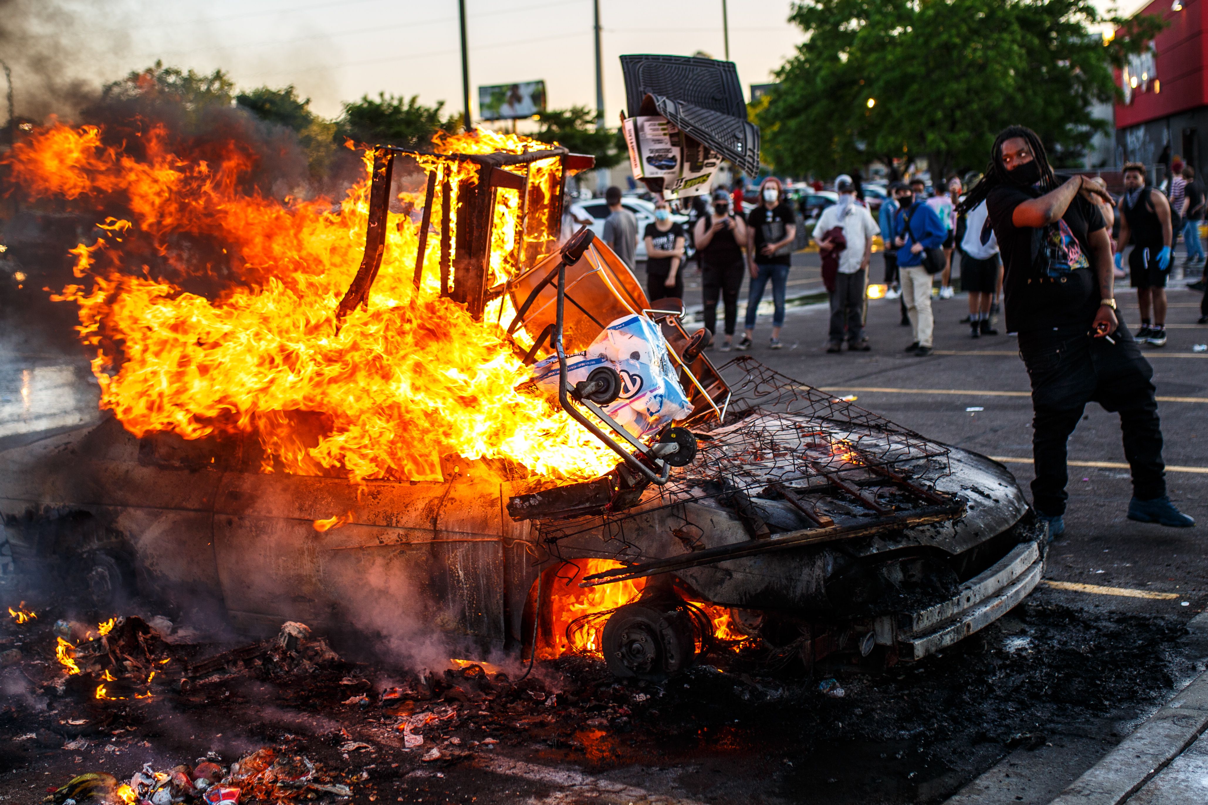 Protesters throw objects into a fire outside a Target store near the Third Police Precinct on May 28, 2020 in Minneapolis, Minnesota, during a demonstration over the death of George Floyd. A police precinct in Minnesota went up in flames late on May 28 in a third day of demonstrations as the Twin Cities of Minneapolis and St. Paul seethed over the shocking police killing of Floyd.