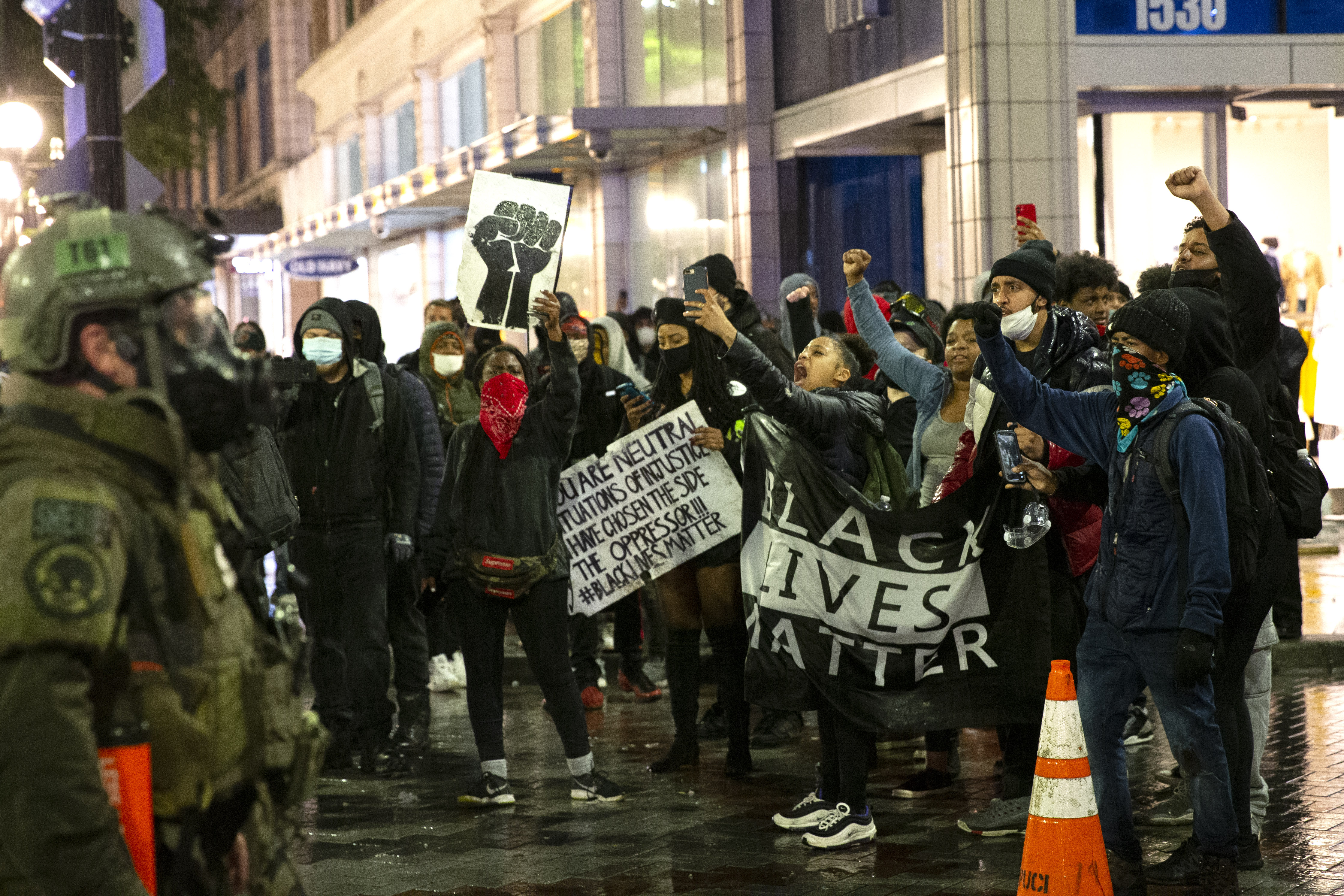 Protesters holding a Black Lives Matter banner shout at law enforcement officers on May 30, 2020, in Seattle, Washington. A peaceful rally was held earlier in the day expressing outrage over the death of George Floyd who died while in the custody of police in Minneapolis. Police deployed flash bangs and tear gas to break up the crowd who were breaking windows and looting stores.