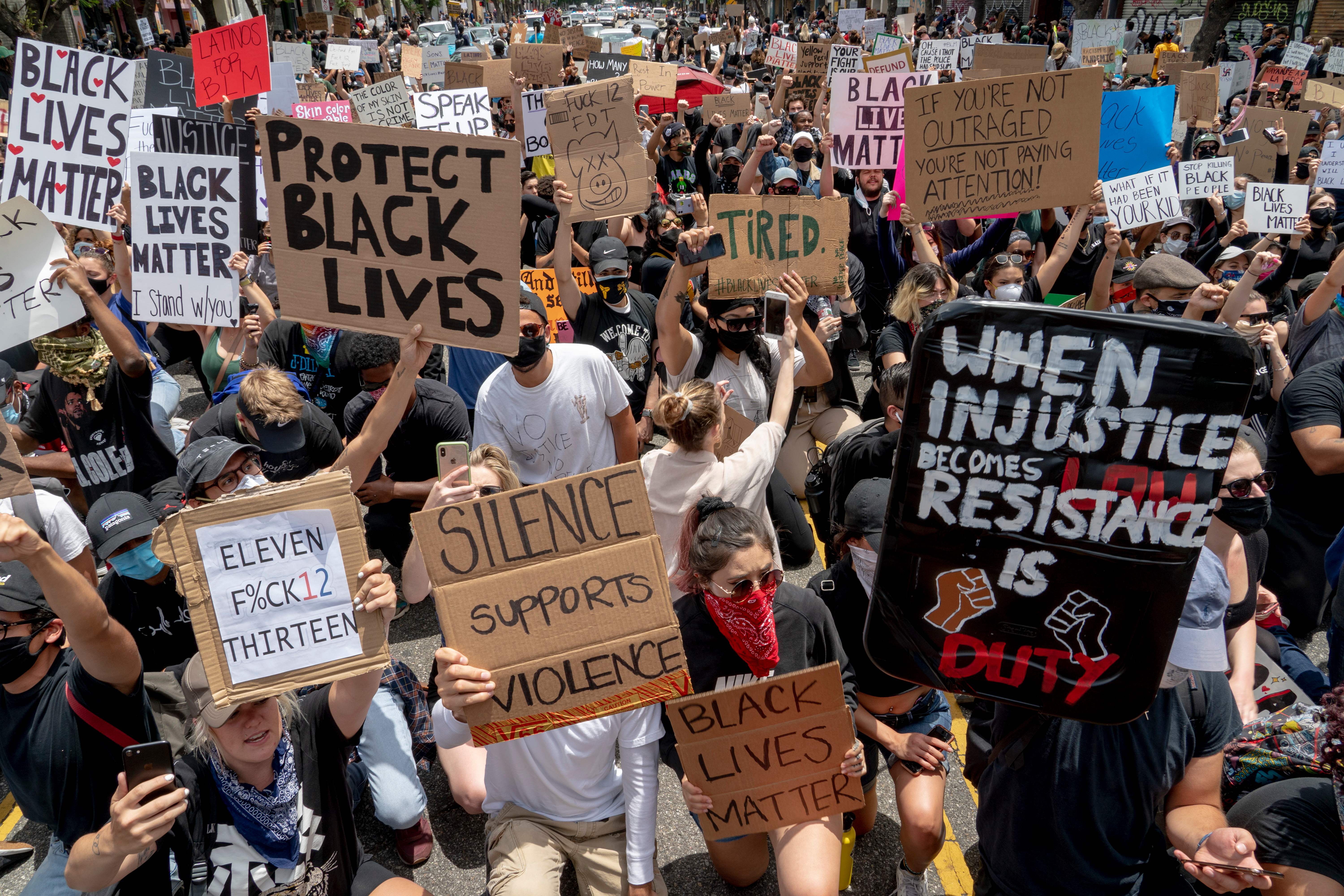 Protestors kneel in front of the police during a demonstration over the death of George Floyd and pattern of police brutality against black Americans in Hollywood, June 2, 2020.