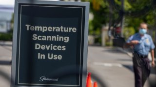 A sign stating that temperature scanning devices are in use is seen at Paramount Pictures Studios as Los Angeles County allows more businesses and facilities to reopen today, despite rising COVID-19 infections and deaths on June 12, 2020 in Los Angeles, California. After reporting the largest single-day jump in coronavirus cases, health officials are warning that the county’s transmission rate of the disease could overwhelm intensive-care units in the next two to four weeks if the increase isn’t reversed. Newly allowed reopenings include gyms and fitness facilities, spectator-free sports venues, day camps, museums, galleries, zoos, aquariums, campgrounds, RV parks, outdoor recreational areas including swimming pools, music, film and television production and hotels for leisure travel. The county’s death toll is currently more than 2,800 with the total number of cases nearing 69,000.