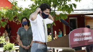 Justin Trudeau, Canada's prime minister, puts on a protective mask following a news conference in Chelsea, Quebec, Canada, on Friday, June 19, 2020. The federal government said earlier this month landlords had applied for only C$90 million ($66 million) from a rent assistance fund on behalf of about 26,000 tenants. That's less than 5% of its estimate of C$2 billion when the program was introduced in April.