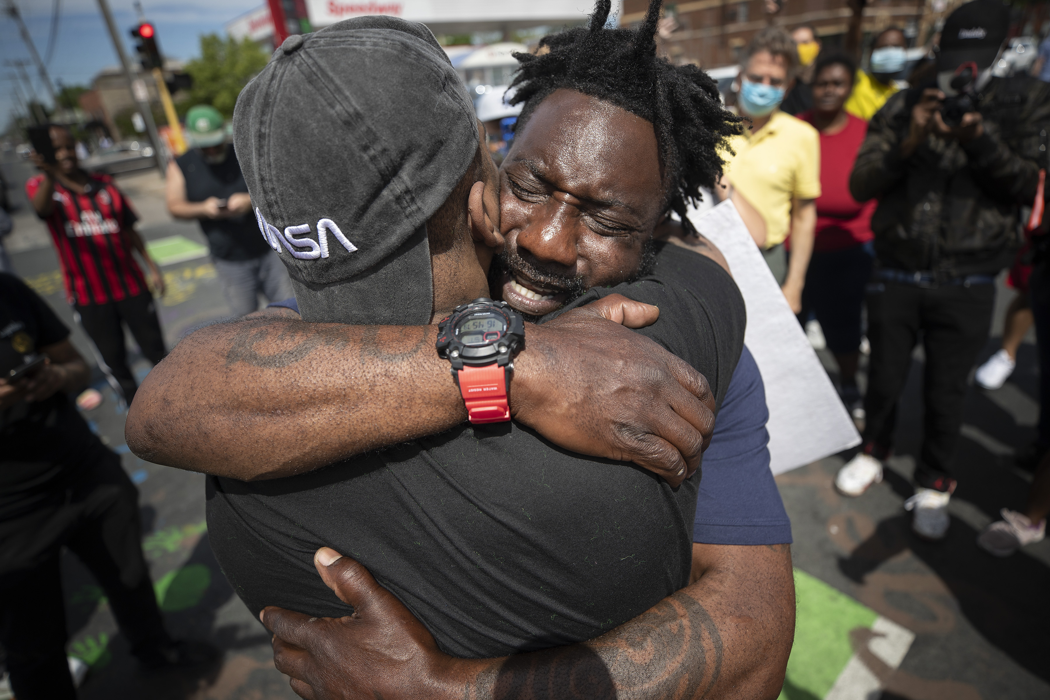 Former Minnesota Gopher and NFL player Tyrone Carter pleaded with protesters not to tear up their city as he hugged Tony L Clark at the site where George Floyd was killed at the hands of Minneapolis police.