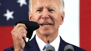 Democratic presidential candidate, former Vice President Joe Biden holds up a mask as he speaks during a campaign event June 30, 2020 at Alexis I. Dupont High School in Wilmington, Delaware. Biden discussed the Trump Administration’s handling of the COVID-19 pandemic. (