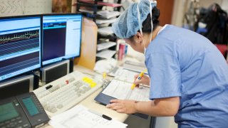 Stock photo of a nurse preparing surgical paperwork